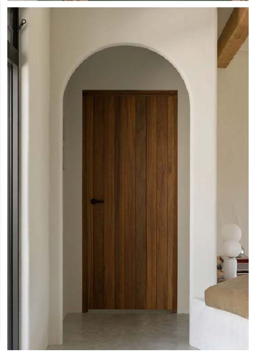Arched timber internal door in a rendered hallway