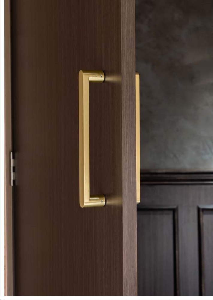 Walnut entrance door with a brass offset pull handle